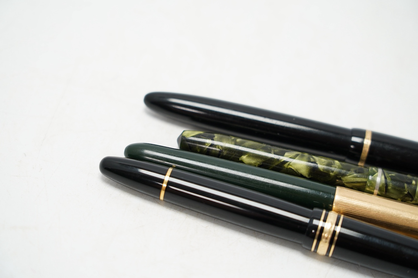 A Montblanc fountain pen with 14k gold nib and three others comprising two Parker’s and a marbleised example